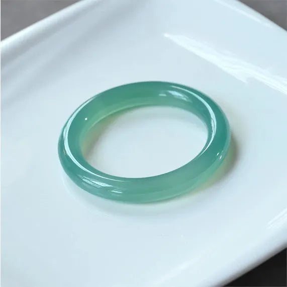 Natural agate wide tire bracelet shown in a pink agate colour variant on a wrist.