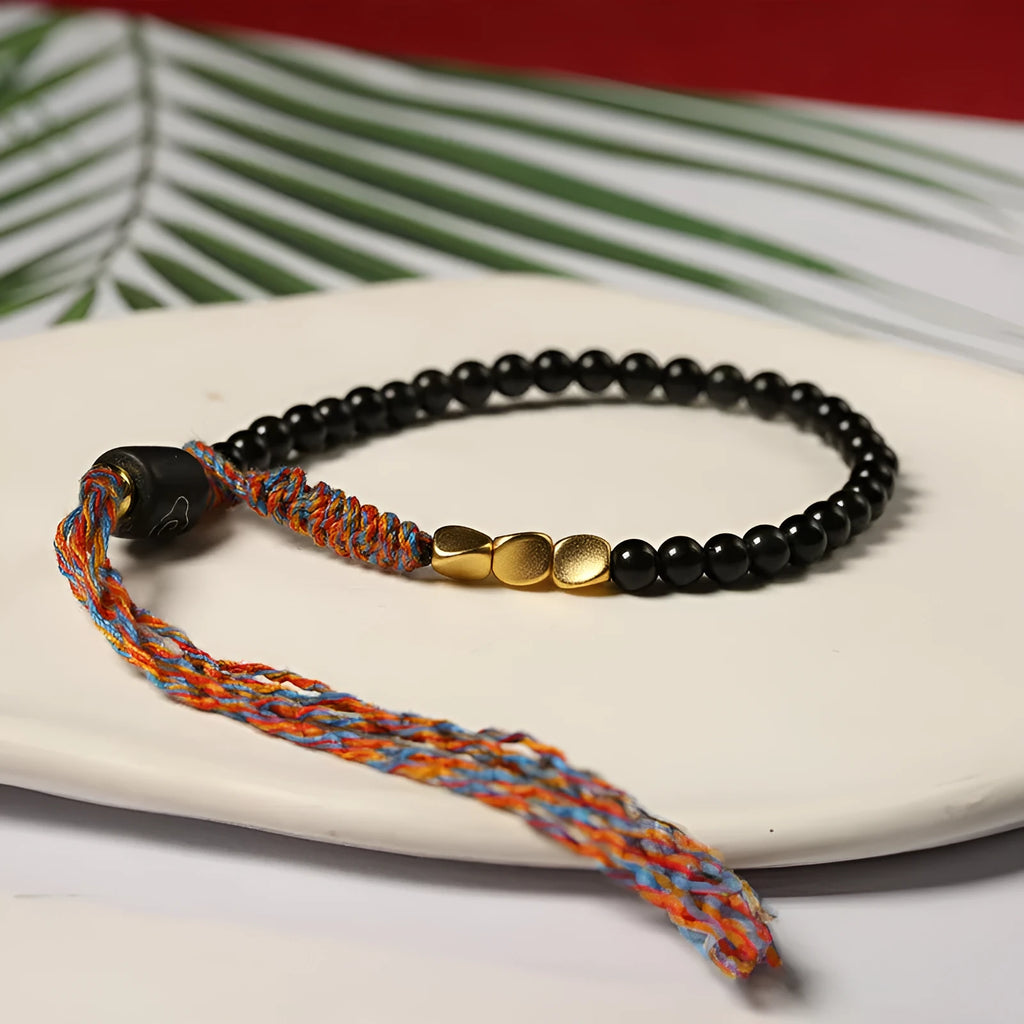 Hand-woven obsidian wrist bracelet showing 4mm width and textured strand construction