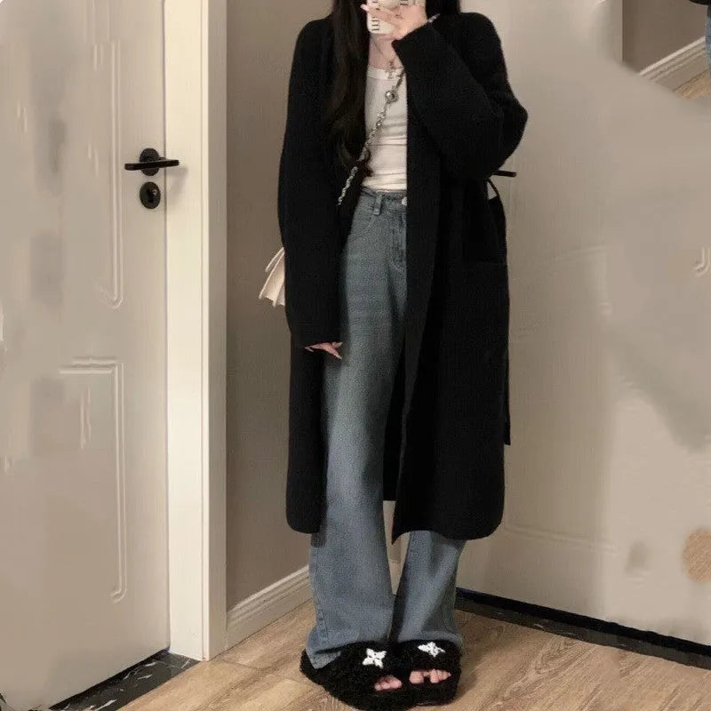 Women's loose black chenille cardigan with a 3D pattern and long sleeves on a hanger.