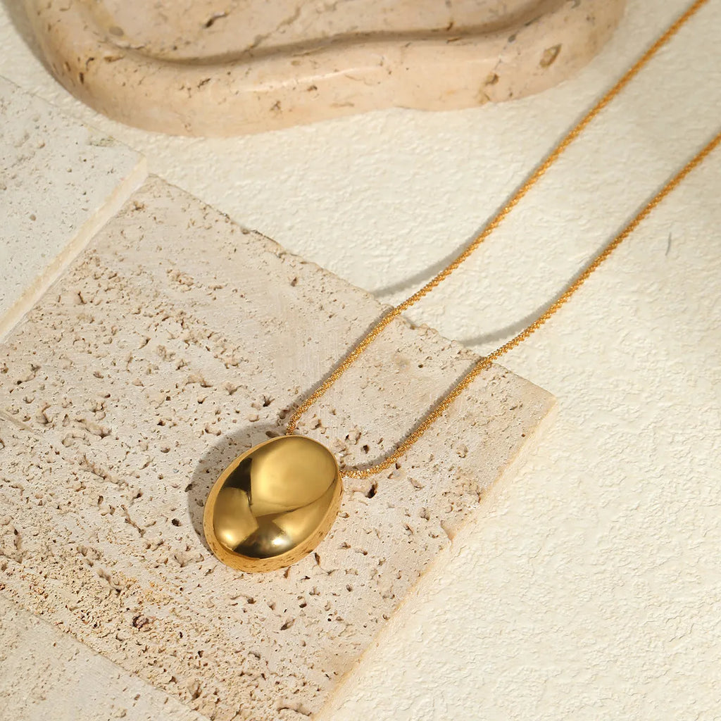 Gold geometric pendant necklace with adjustable chain on jewellery display