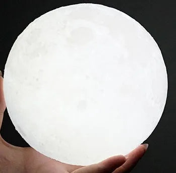 3D printed white moon lamp with detailed craters on a wooden stand, showing touch ring at base.