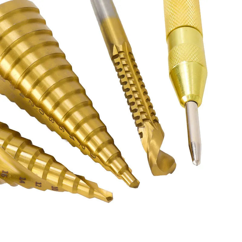 Cone-shaped step drill bits and a centre punch from a high-speed steel tool set on a workshop bench.