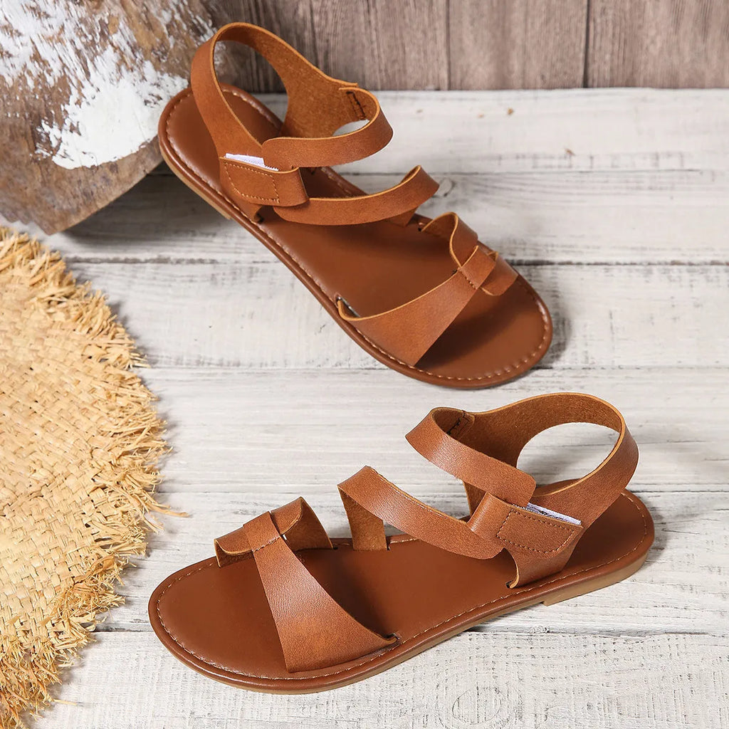 Women's flat sandals with a Velcro strap closure, shown in a choice of colours on a rubber sole.