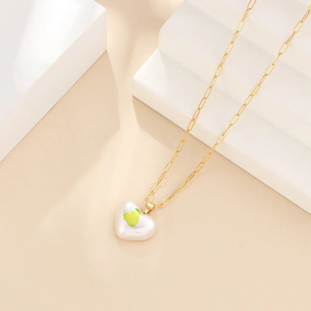 Adjustable heart necklace showing geometric fruit pendants: apple, pineapple, strawberry, cherry, and pear.