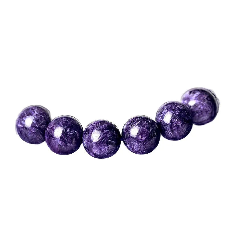 Natural transparent charoite crystal bracelet with platinum fastening on a wrist.