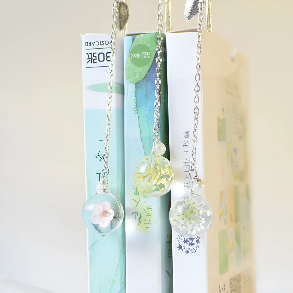 Alloy metal bookmark pendant with dried flower specimen, showing colour options on a 12 cm scale.