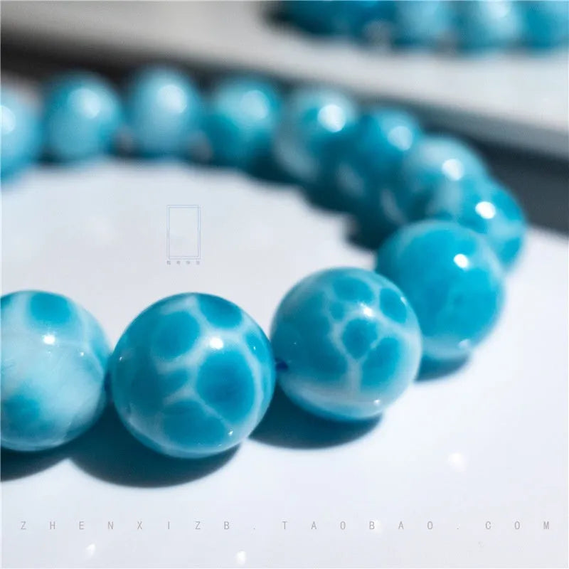 Blue Bodhi bracelet with natural sea-pattern crystal bead and pearl details in Maillard style.