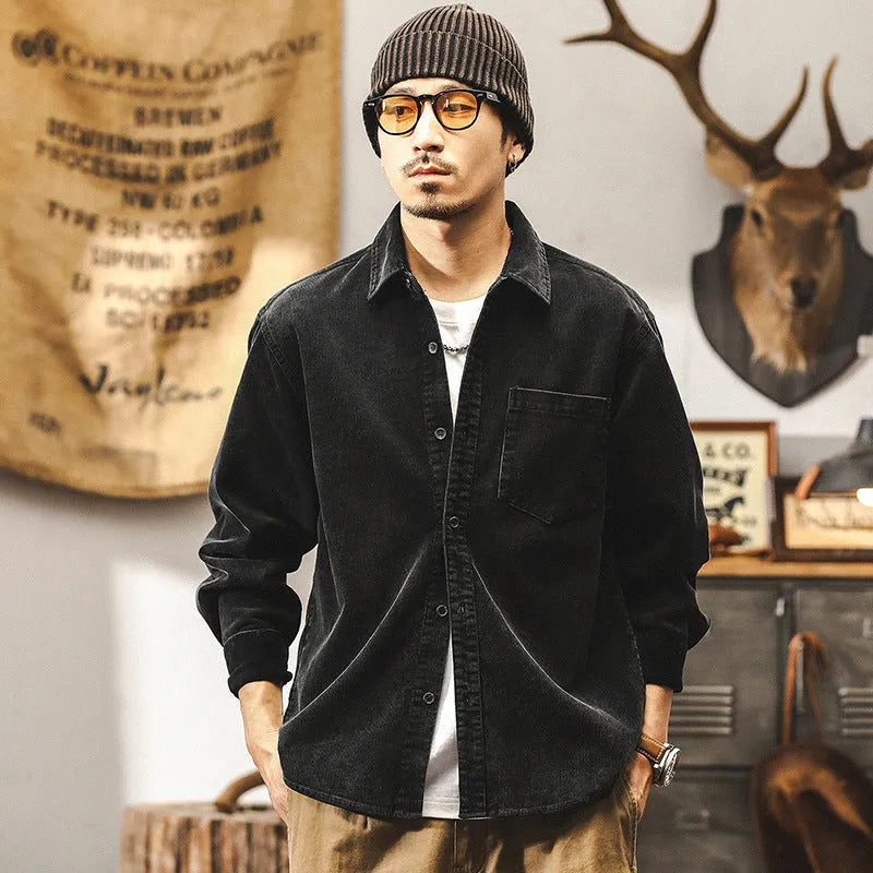 Men's black loose-fit corduroy shirt jacket with long sleeves on a hanger.