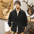 Men's black loose-fit corduroy shirt jacket with long sleeves on a hanger.
