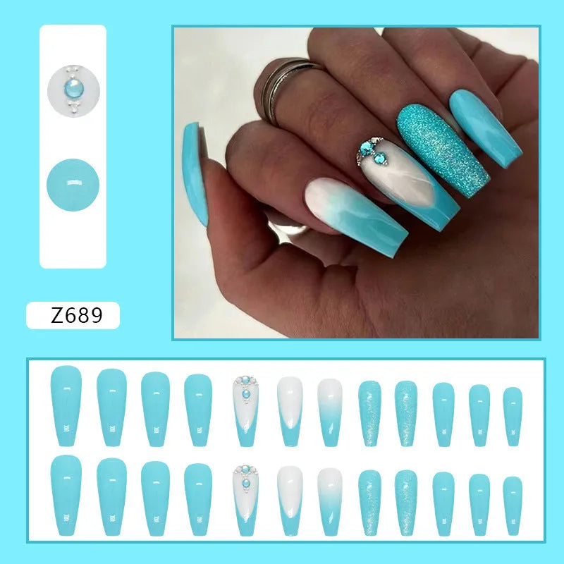 Long ballet false nails with blue diamond glitter on solid colour background with nail glue bottle