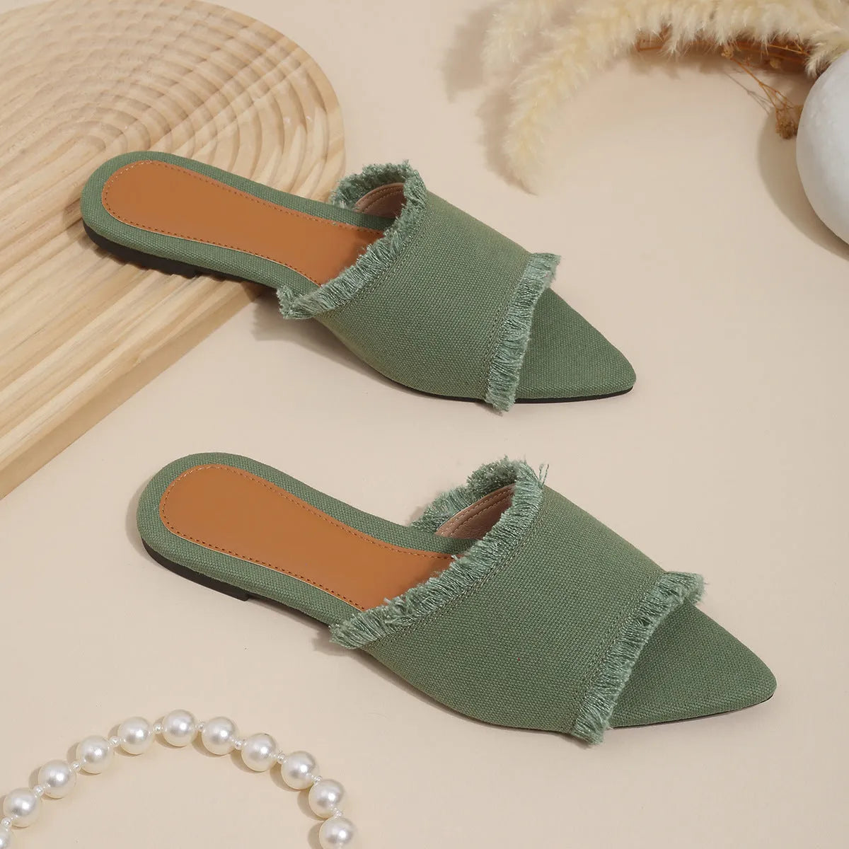 Women's denim flat slippers with tassel detail and leather lining in apricot colour.
