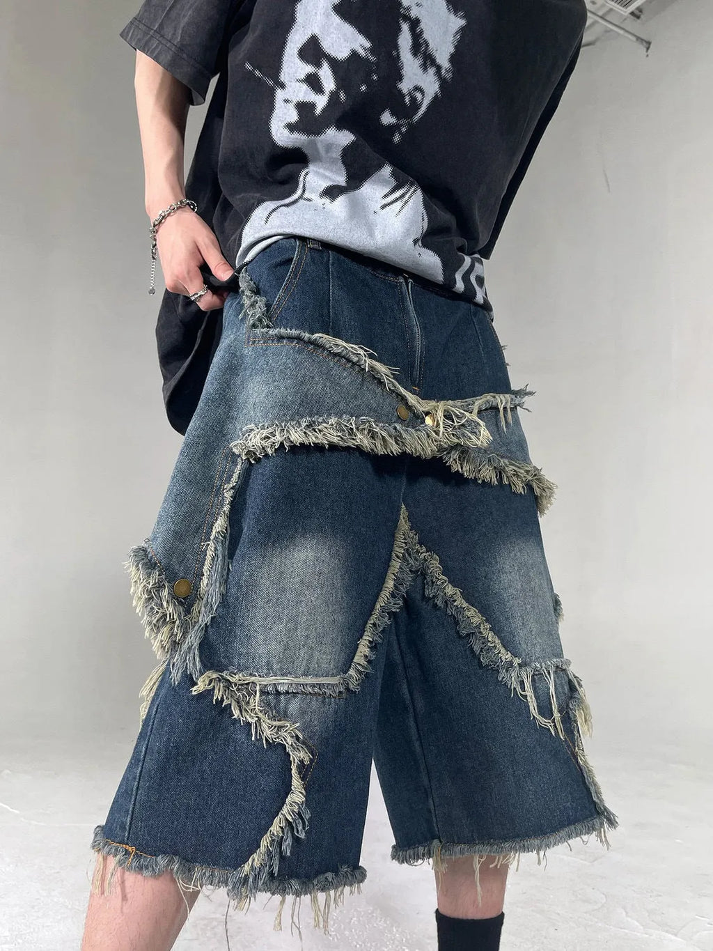 Blue loose-fit men's denim shorts with a frayed hem and a large retro star design on the leg.