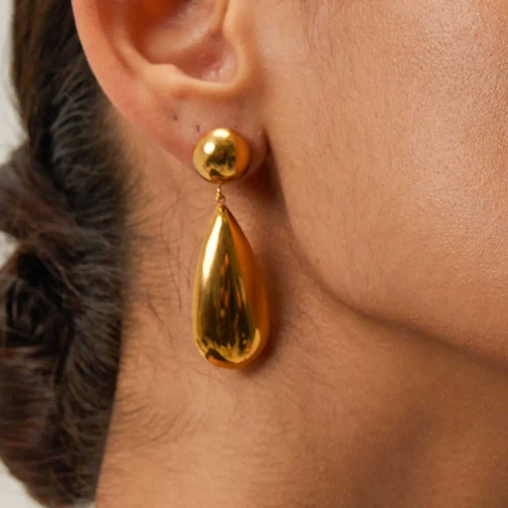 Gold stainless steel earrings with geometric hemisphere shape and water drop pendant design