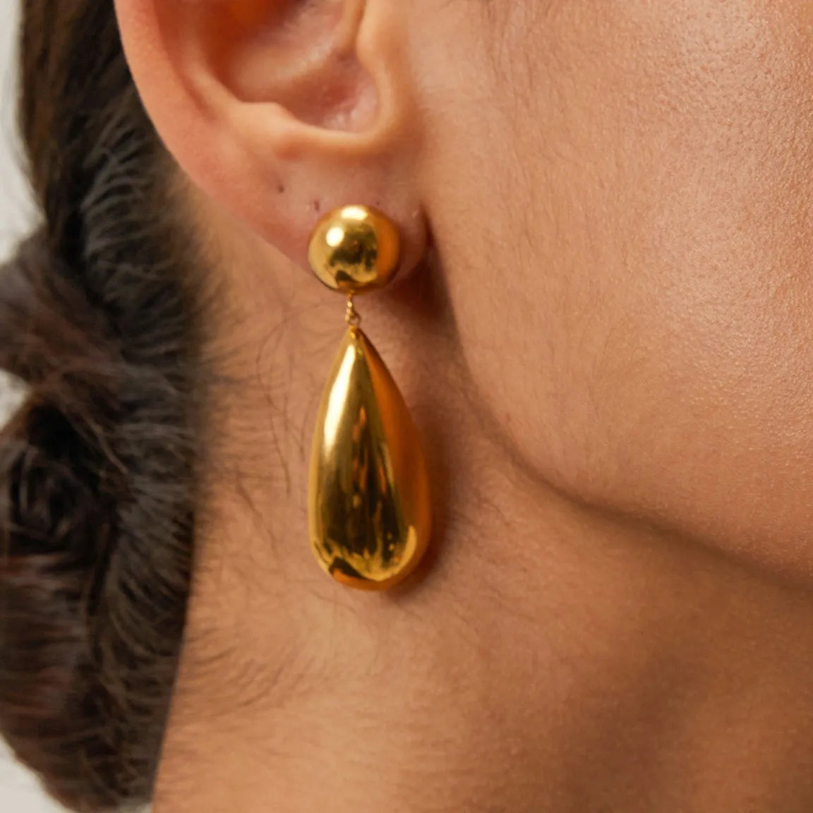 Gold stainless steel earrings with geometric hemisphere shape and water drop pendant design