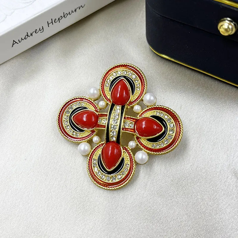 Close-up of a metallic medieval baroque cross brooch with crystal details on a dark background