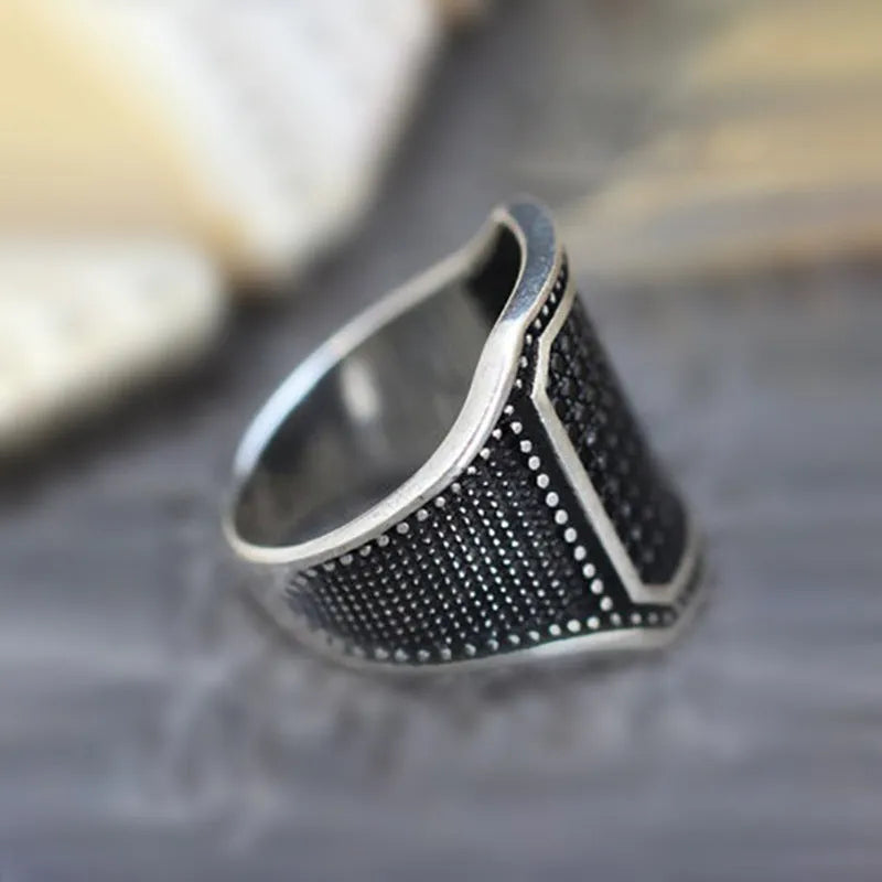 Black alloy ring with copper inlay and zircon accents on a finger, showing European and American styling.