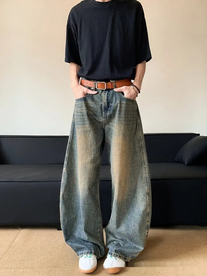 Men modelling retro blue distressed wide-leg jeans with machete detailing and a slimming fit.