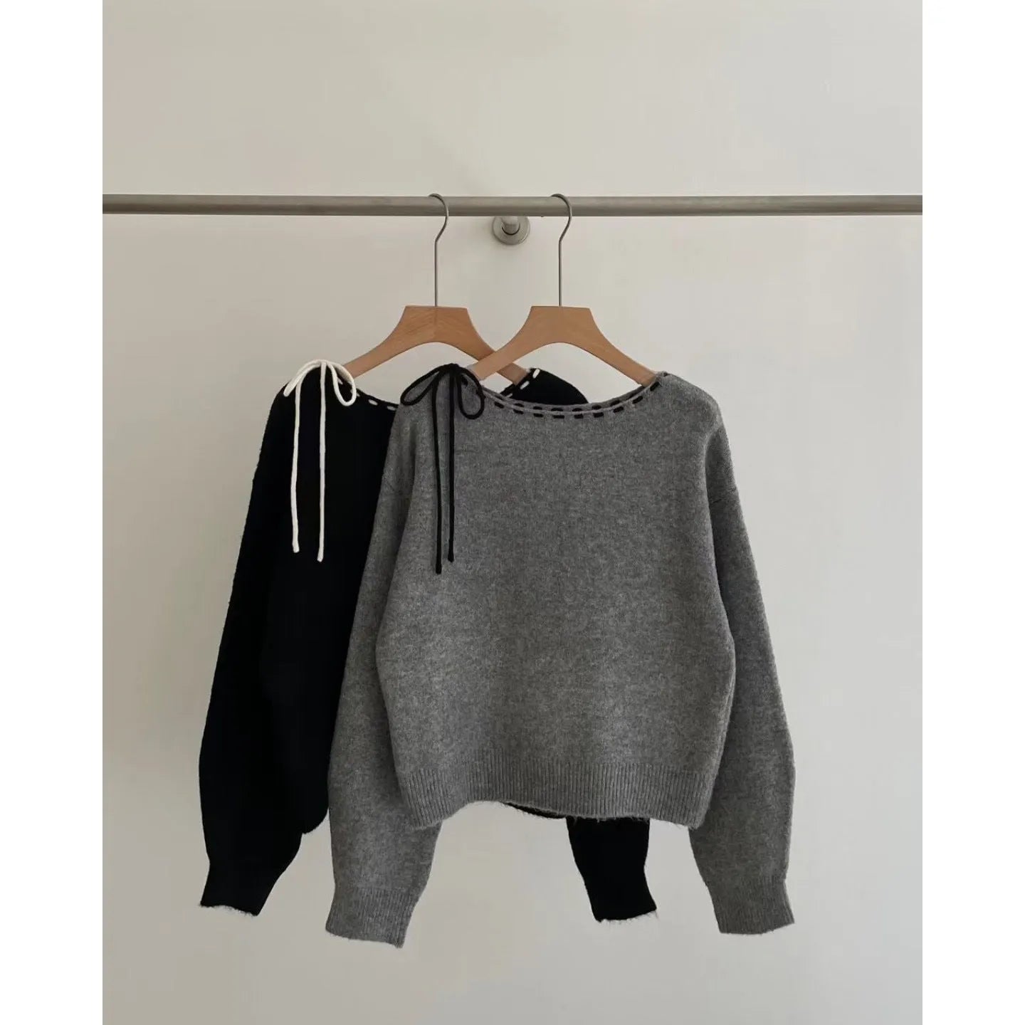 Women's loose-fitting black knitwear pullover jumper on a hanger.