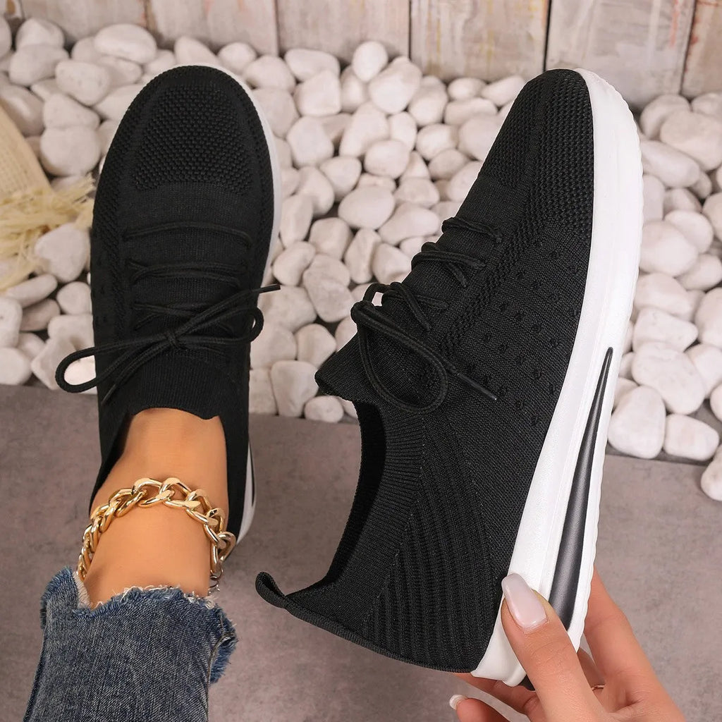 Women's low-top red casual sneakers with round toe and white lace-up front on a plain background.