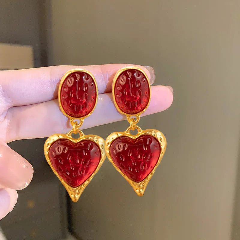 Four pairs of oval love heart stud earrings with silver needle pleated detailing in purple, red, green, and yellow-white colours
