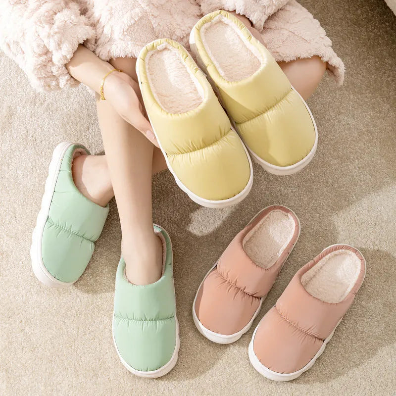 A pair of thick-soled plush slippers with artificial leather uppers and non-slip rubber soles in a choice of five colours.
