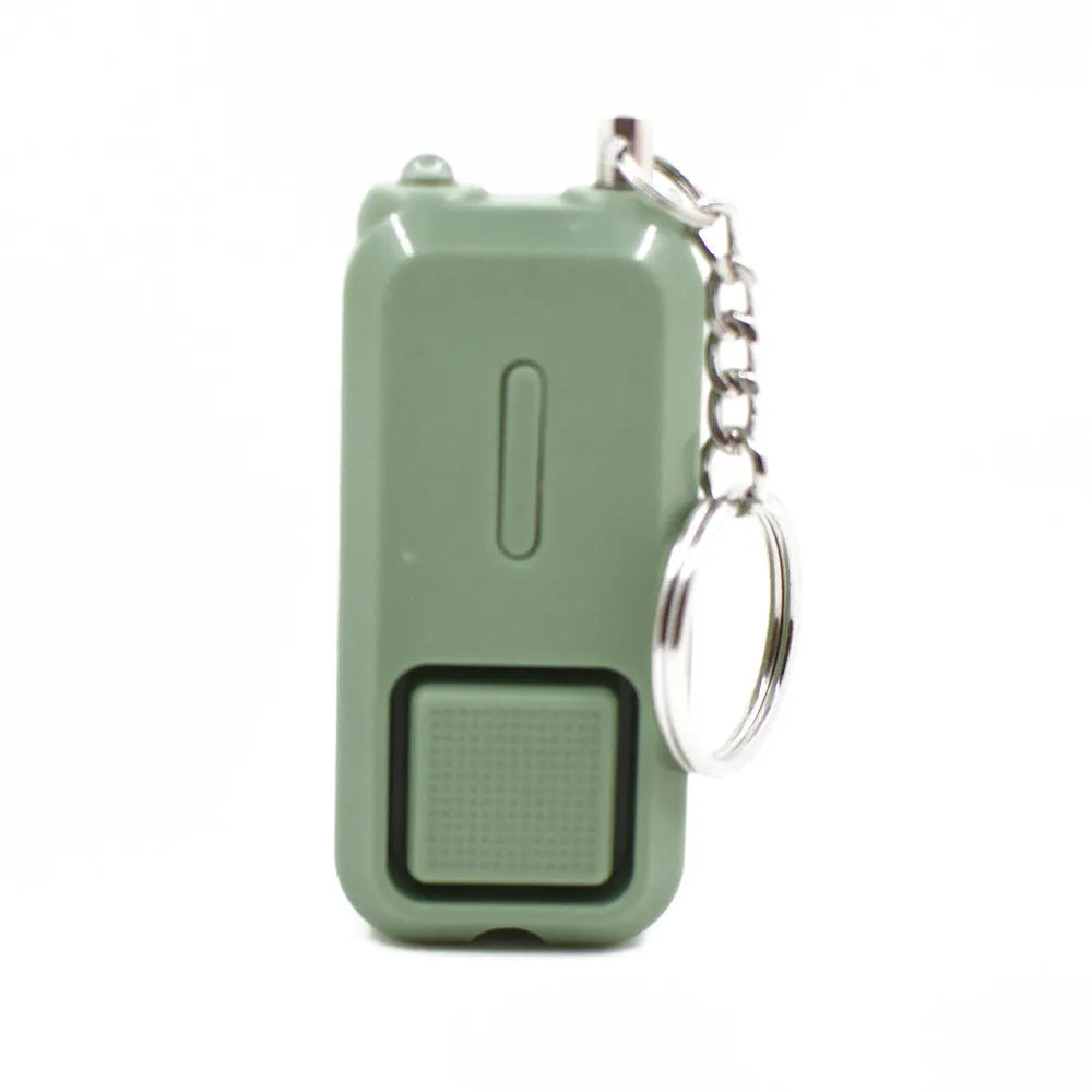 Small pink personal safety alarm on a keyring with a white box.