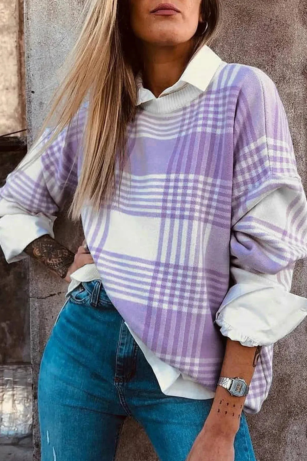 Lilac plaid print loose sweater with ribbed cuffs and collar on a hanger.