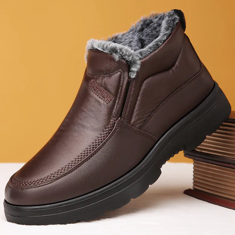 Men's black fleece-lined winter slip-on shoes with a non-slip rubber sole on a wooden floor.