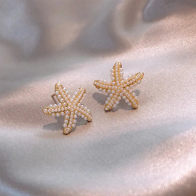 Gold colour Korean-style drop earrings featuring a pineapple and starfish design with pearl and gemstone inlay.