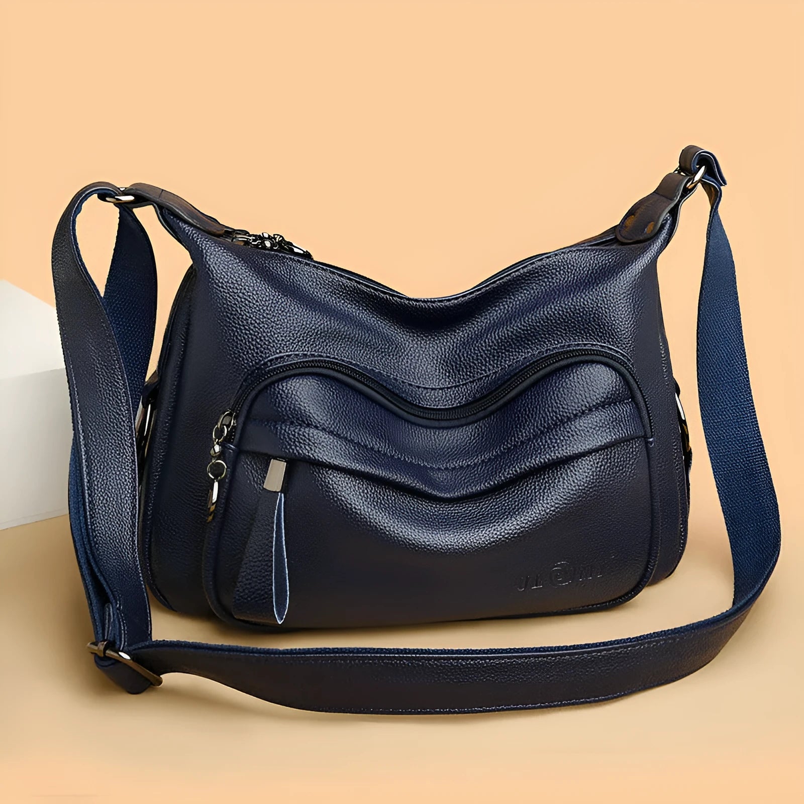 Large blue women's crossbody shoulder bag with a zipper and soft handle, shown with internal organiser pockets.