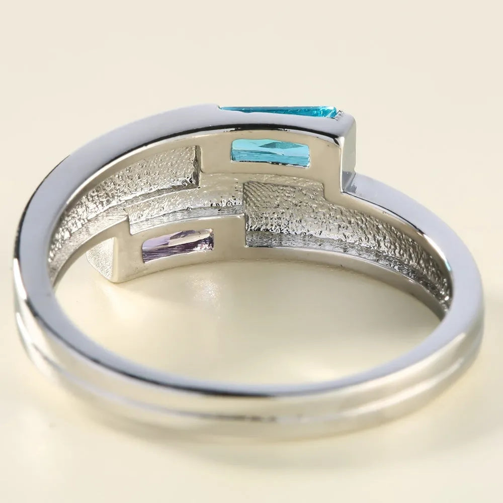 Silver-coloured electroplated copper ring with a zircon stone inlay on a finger.