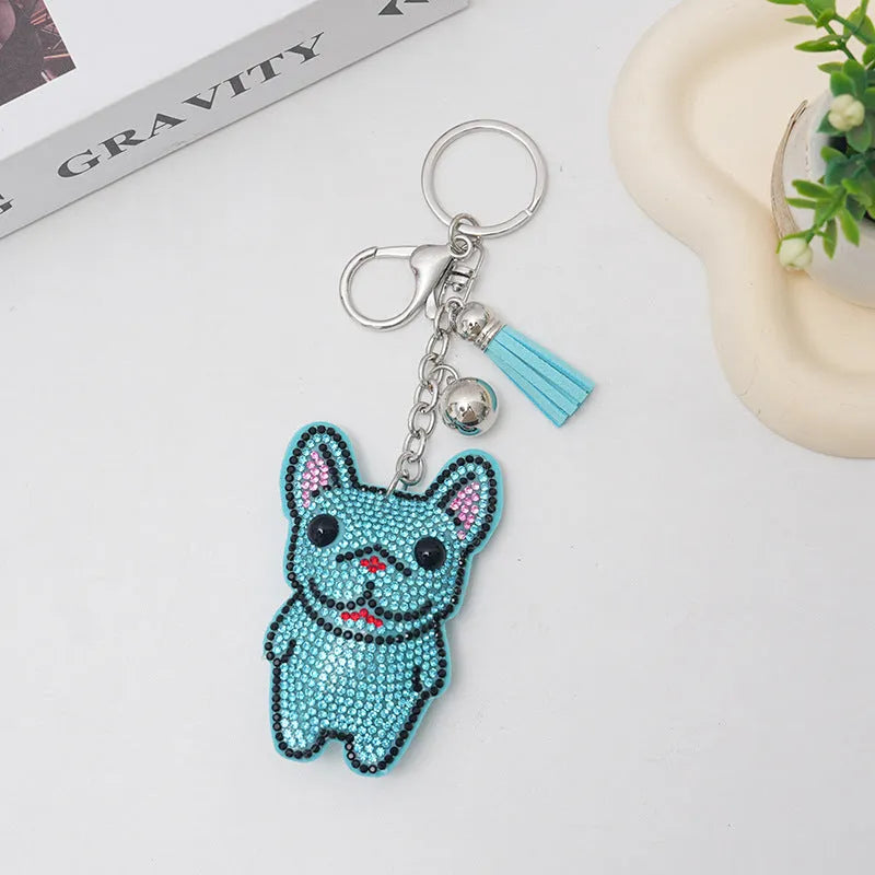 Close-up of a rhinestone and alloy French dog cartoon keychain with tassel pendant