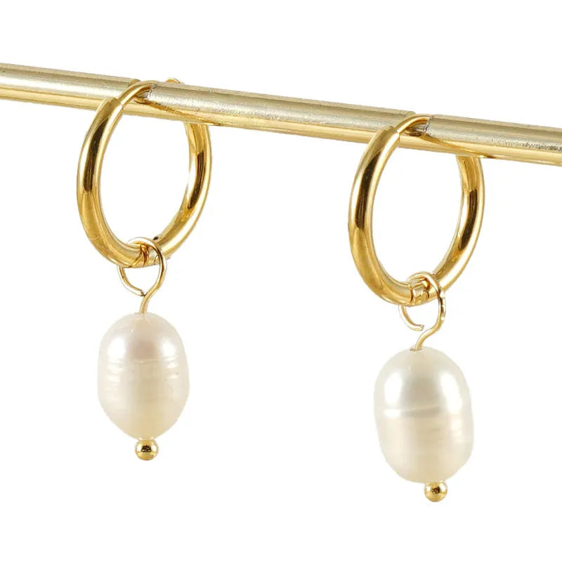 A pair of gold-coloured geometric earrings with a central pearl, made from stainless steel.