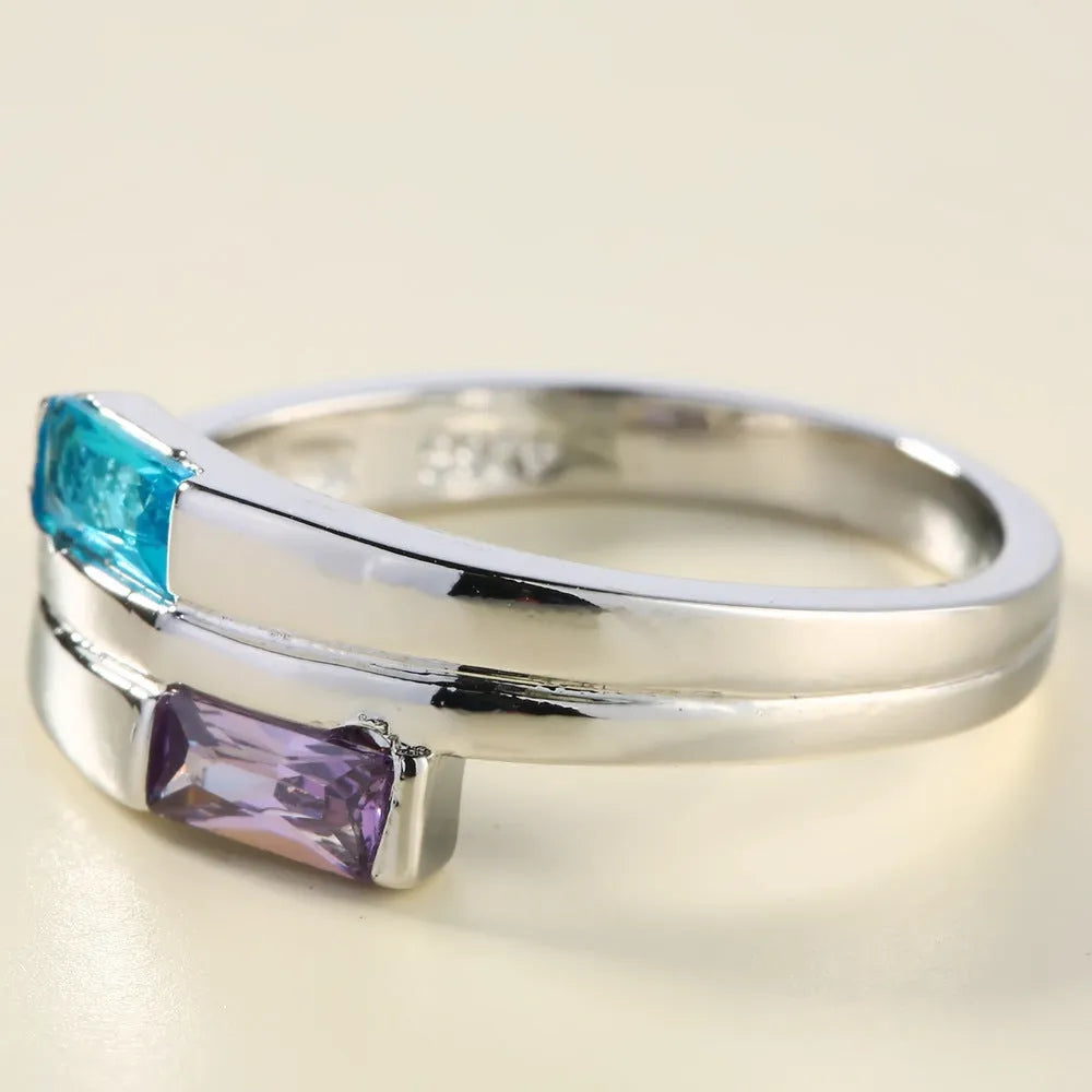 Silver-coloured electroplated copper ring with a zircon stone inlay on a finger.