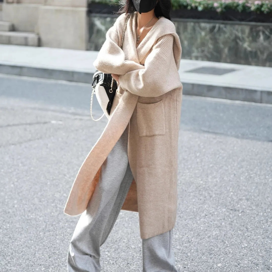 Long grey knitted hooded cardigan coat with a loose fit, shown worn open.