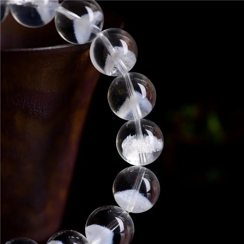 Women's white crystal ghost pyramid bracelet with Ruyi design elements on a wrist.