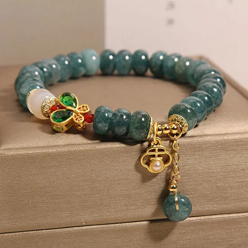 Blue water jade and white agate abacus bead crystal bracelet with rhinestone details and butterfly motif on alloy base