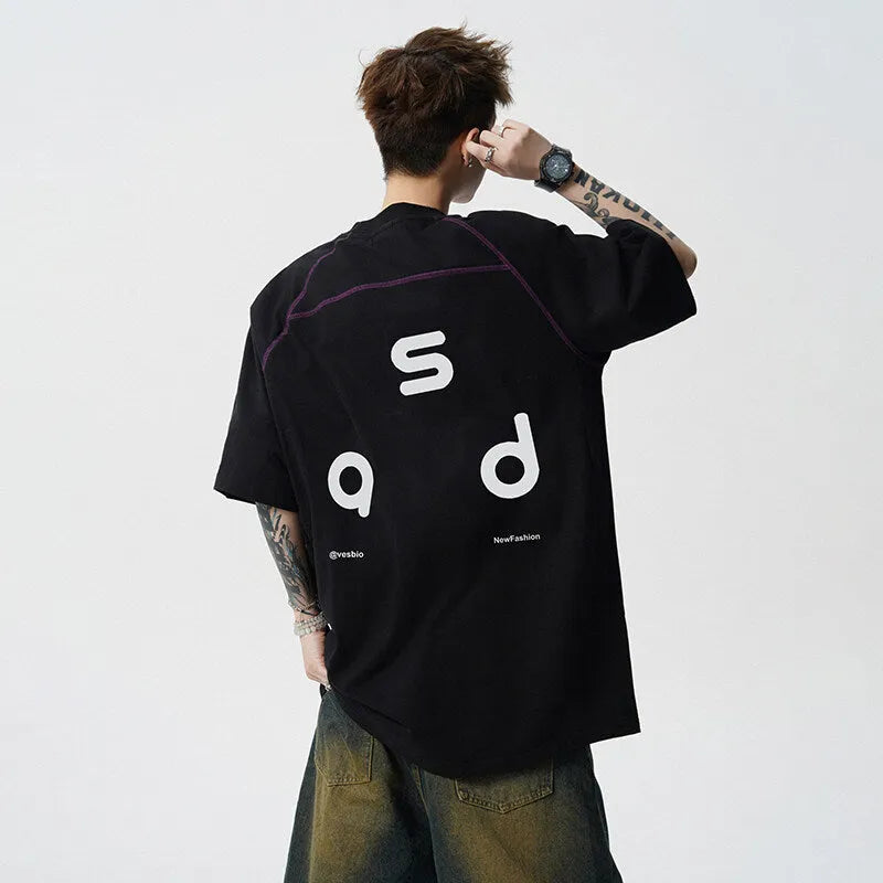 Man wearing a loose fit black cotton t-shirt with a letter print on the chest.
