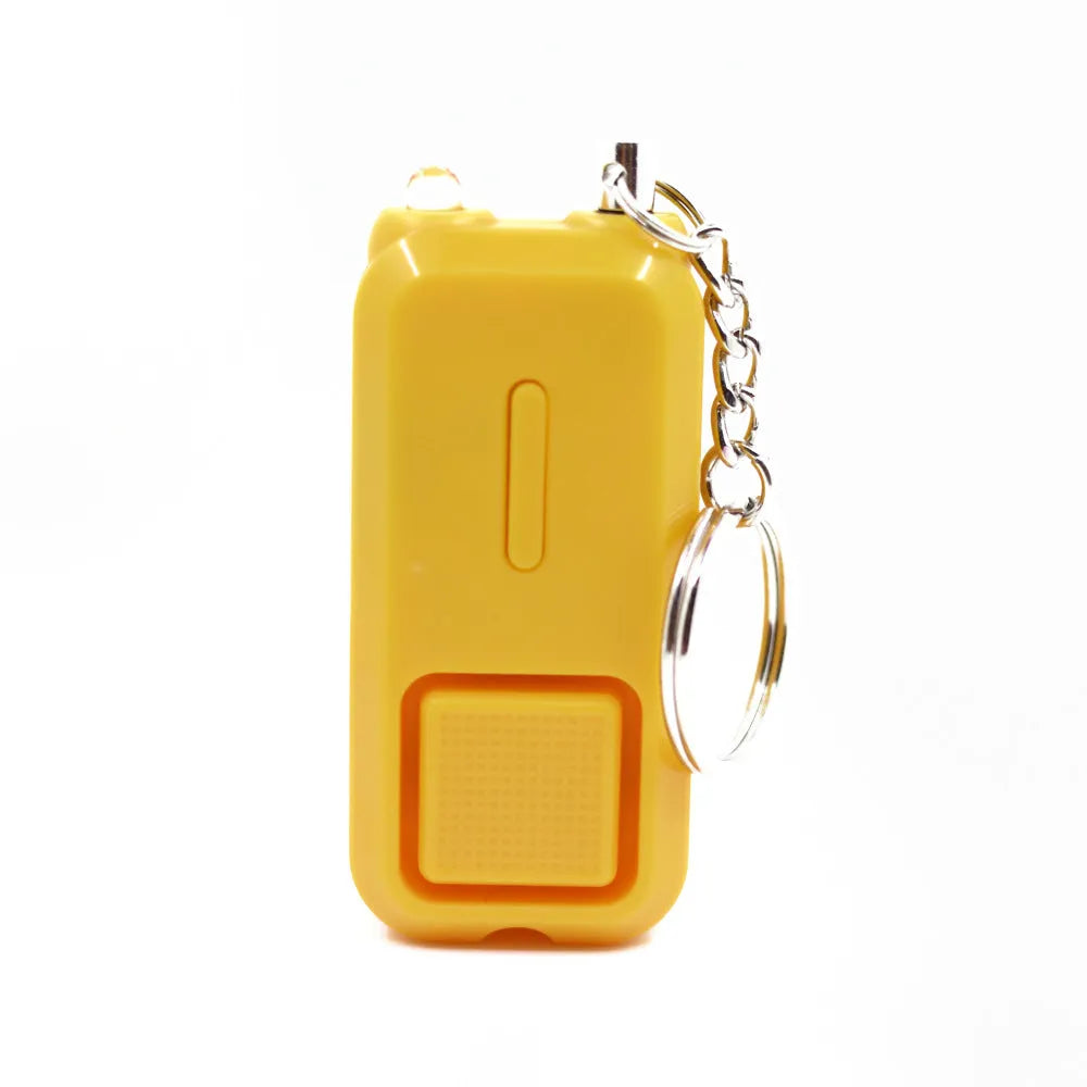 Small pink personal safety alarm on a keyring with a white box.