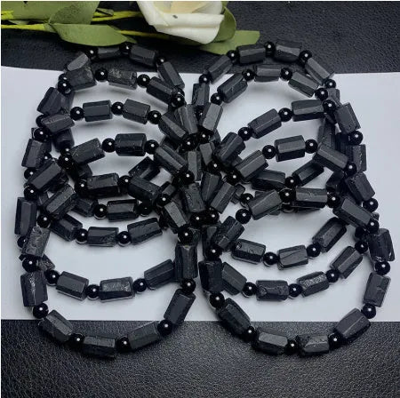 Natural black tourmaline rough stone bracelet showing authentic crystal texture on approximately 9mm beads