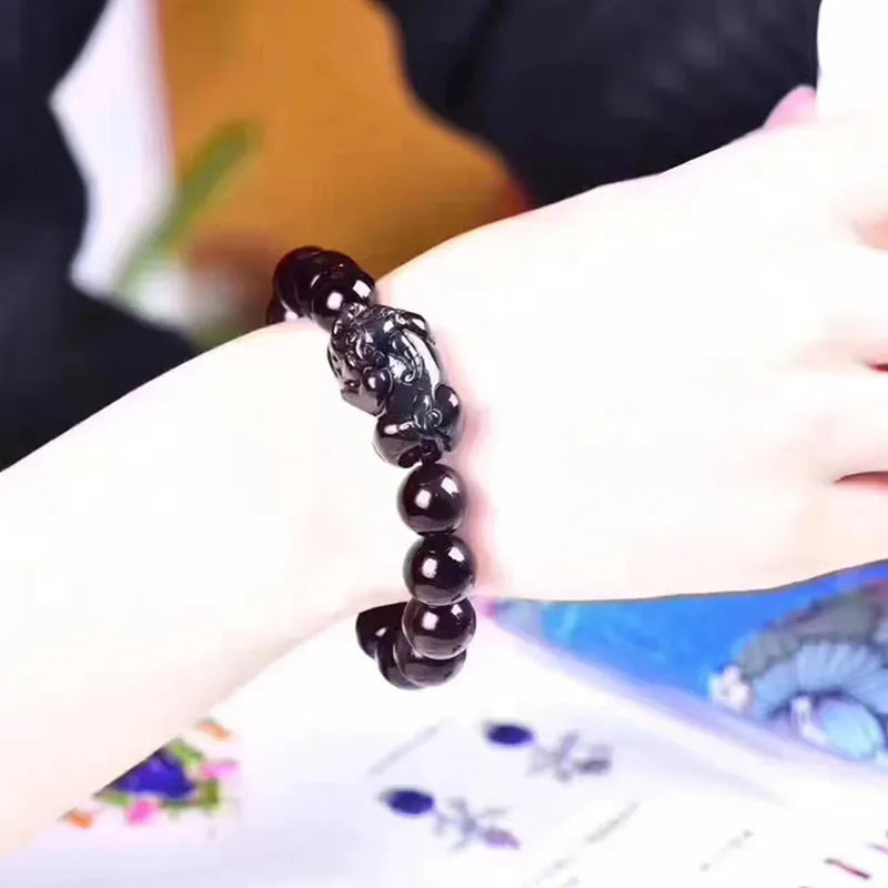 Natural ice colour obsidian crystal bracelet with spherical beads on a neutral background.