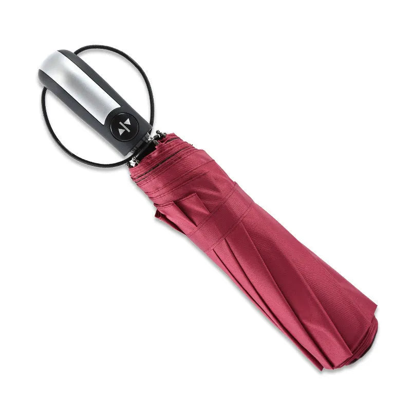 Black triple folding automatic business umbrella with steel ribs and a rubber handle.