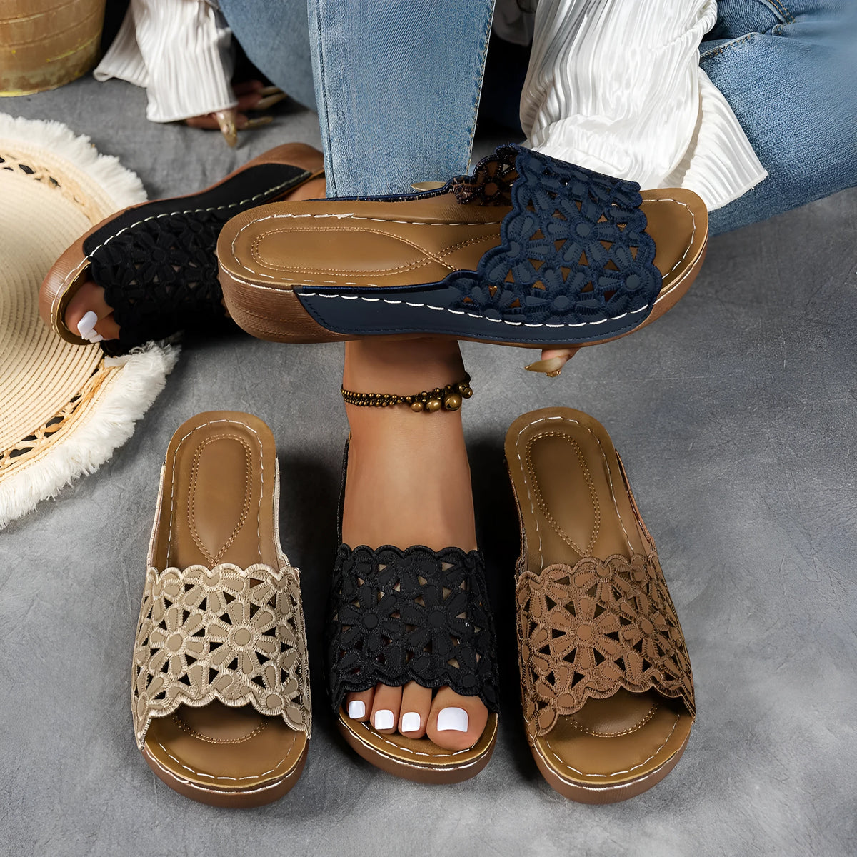 Black women's wedge beach sandals with a floral cutout pattern on the PVC upper.