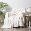 Shu cotton velvet jacquard sofa blanket in a solid colour draped over a modern sofa