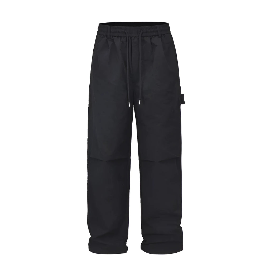 Black baggy paratrooper pants with an elastic waistband on a neutral background.