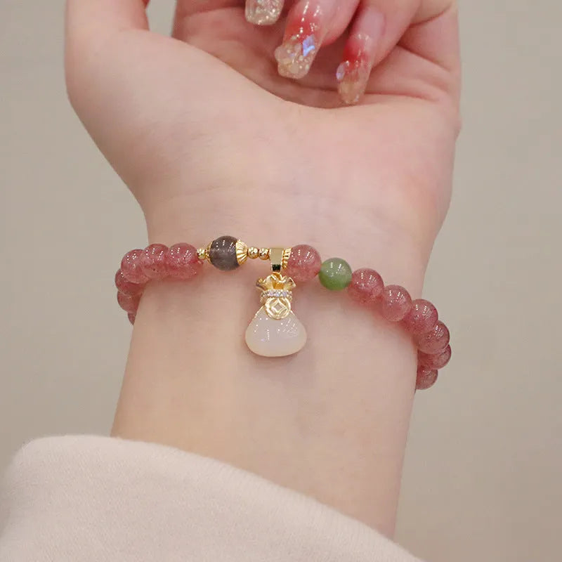 Women's geometric strawberry quartz bracelet with Chinese purse charm and safety buckle clasp.