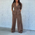 Brown polyester men's slim fit formal suit set with long sleeves and trousers on a hanger.