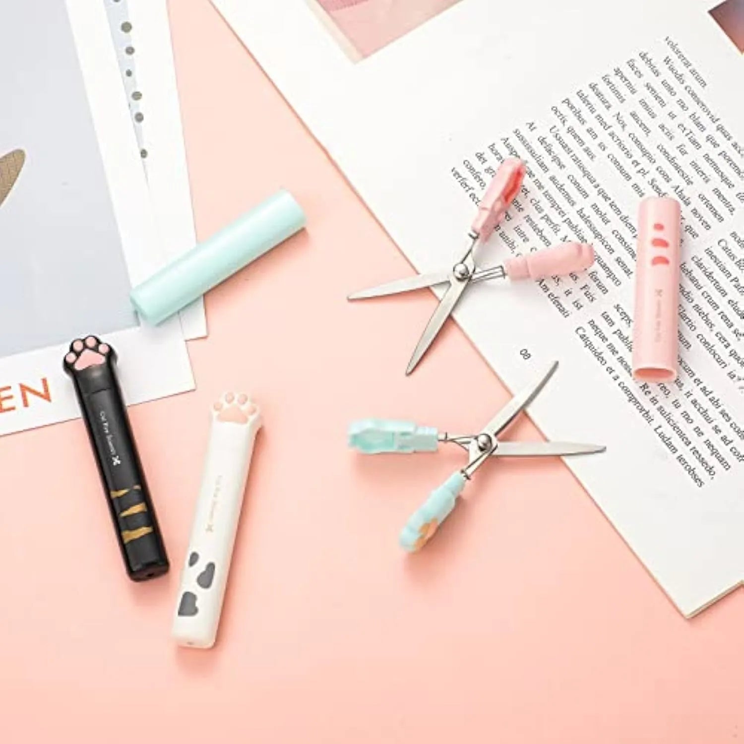 Closed folding mini scissors with cat paw design on handles in blue, pink, black, and white colour options.
