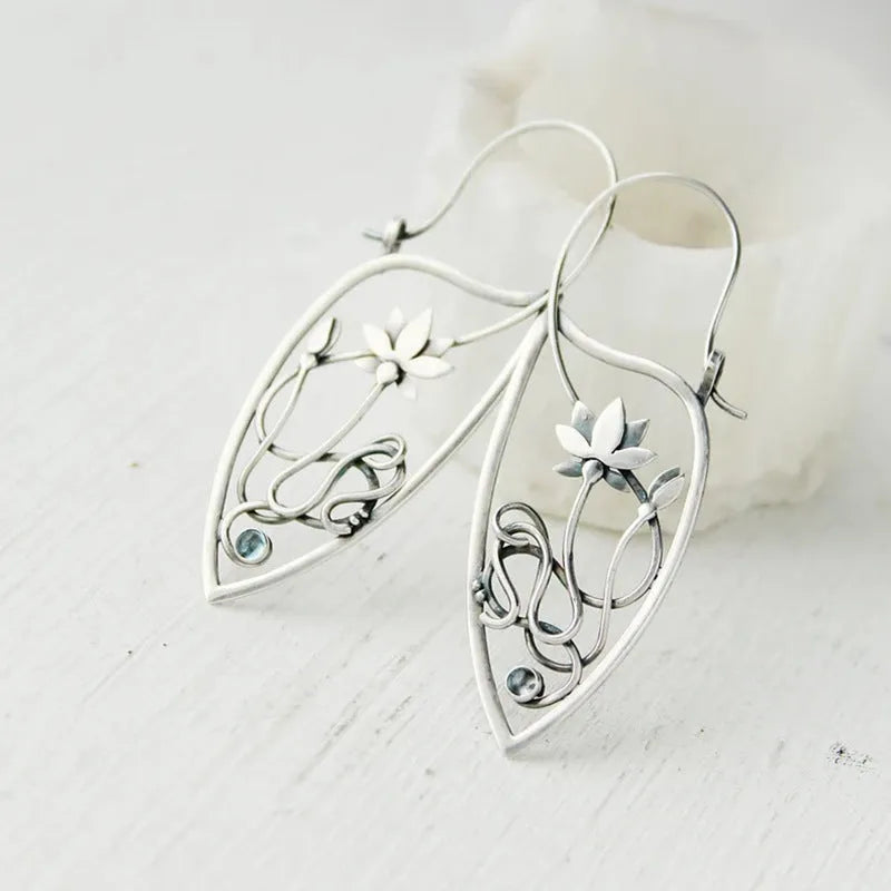 A pair of silver women's earrings with a lotus vine and geometric design featuring round rhinestones.