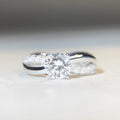Silver ring with 1 karat moissanite stone in four-claw setting and twisted geometric arms